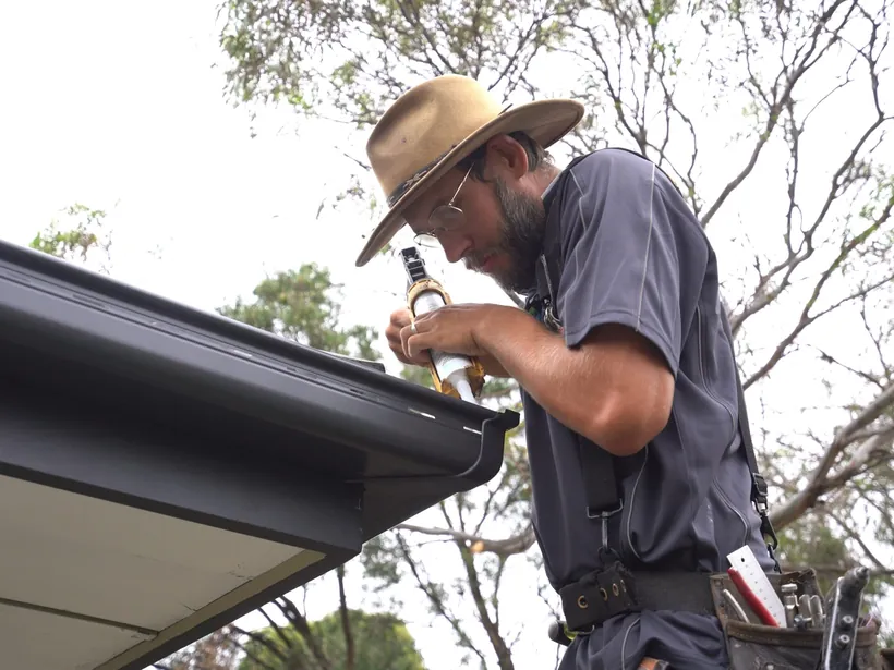 Roof plumber fitting a new gutter